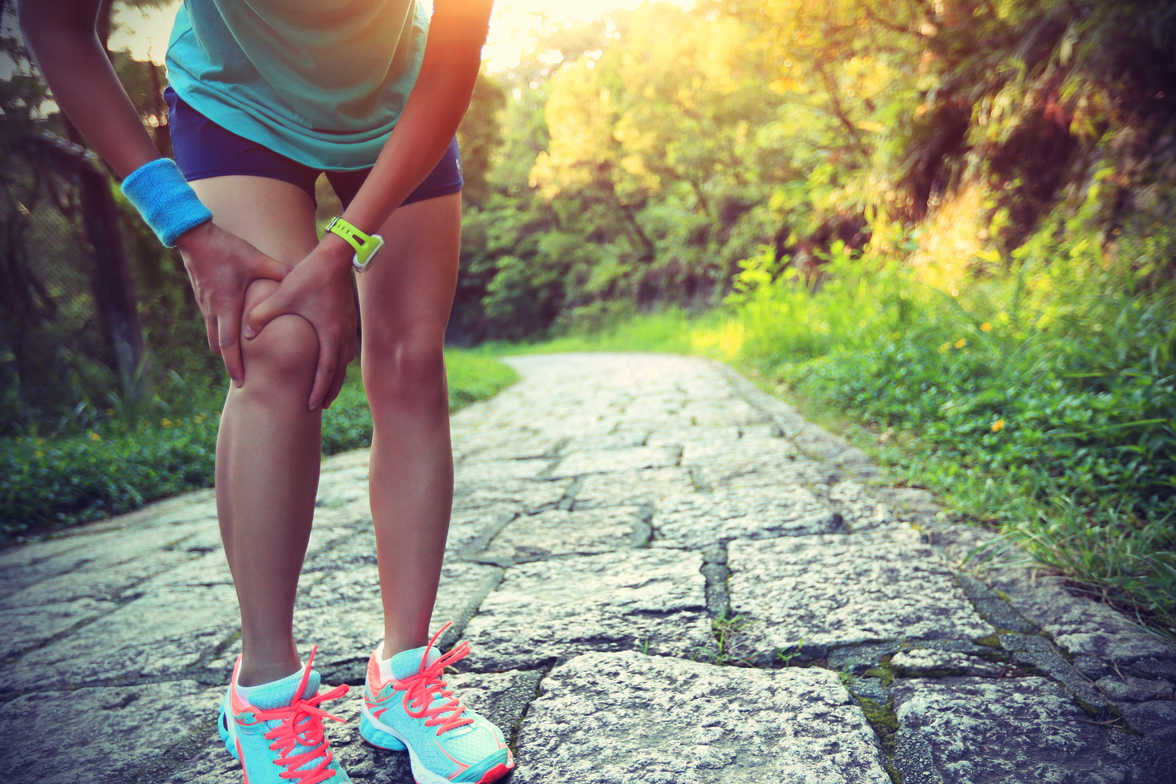 a person holding their knee with both hands indicating injury